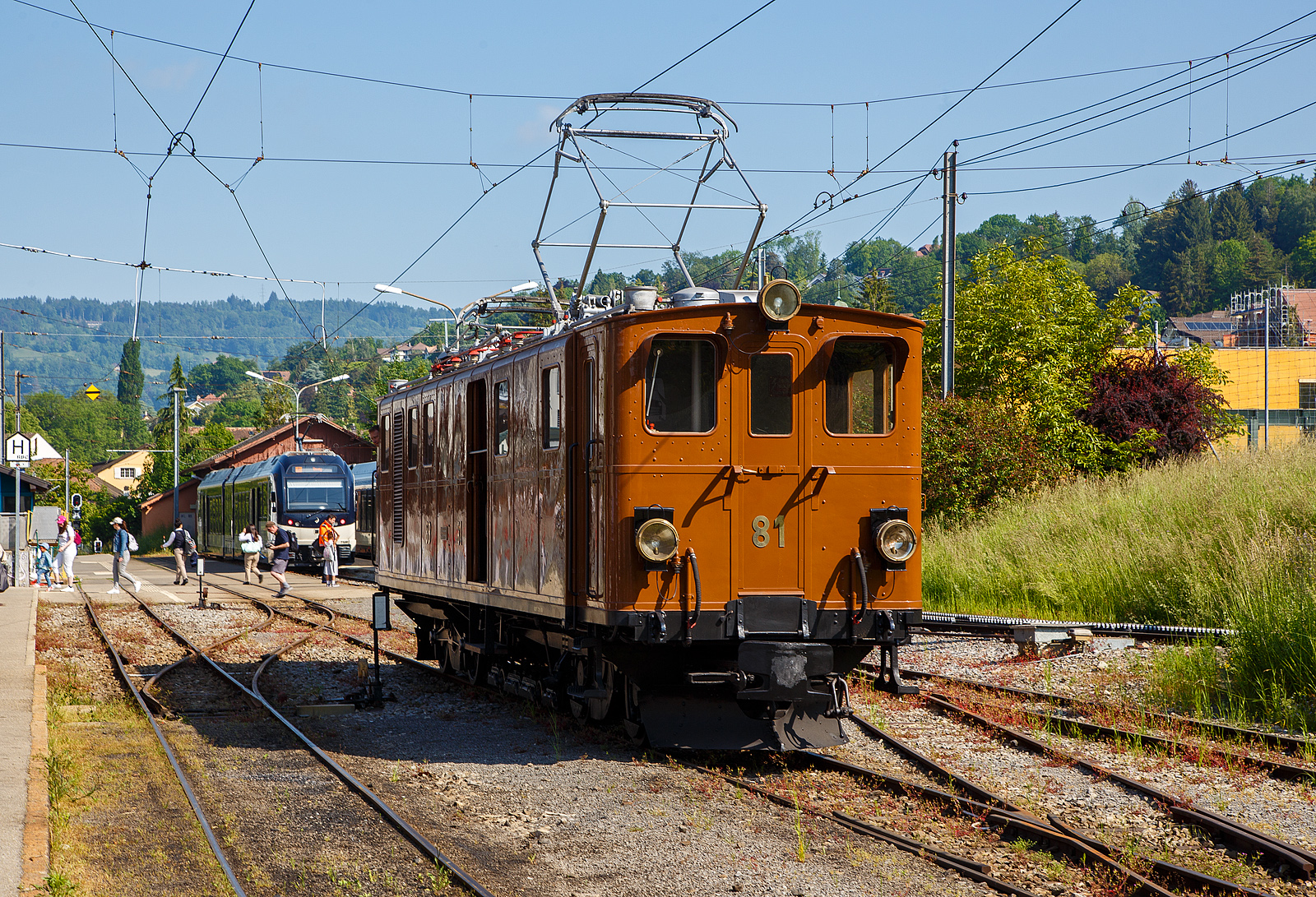 Pfingsten 2023 (Samstag 27. bis Montag 29. Mai 2023) fand bei der Museumsbahn Blonay–Chamby das Schweizer Dampffestival 2023 / Festival suisse de la Vapeur 2023 statt.

Die grandiose ehemalige Berninabahn RhB Ge 4/4 81 der Museumsbahn Blonay–Chamby, ex RhB Ge 4/4 181, ex BB Ge 4/4 81, ex BB Ge 6/6 81, am 27. Mai 2023 beim Umsetzen im Bahnhof Blonay, sie war führte den ersten Zuglauf des Tages. Eigentlich da die Lokomotive ein kleines Gepäckabteil und sechs Achsen besitzt, müsste sie als Triebwagen De 4/6 bzw. Fe 4/6 (ex Fe 6/8) klassifiziert sein, aber die Berninabahn und später die RhB wollten sie als Lokomotive und nicht als Triebwagen klassifizieren.

Die Ge 4/4 81war ursprünglich eine sechsachsige Elektrolokomotive (Ge 6/6) der ehemaligen Berninabahn (BB), welche 1943 in der Rhätischen Bahn (RhB) aufging. Als Einzelstück wurde sie von der Schweizerischen Lokomotivfabrik in Winterthur (SLM) mit elektrischer Ausrüstung von Brown, Boveri & Cie. (BBC) hergestellt und 1916 abgeliefert. Als schmalspurige Elektrolokomotive mit sechs angetriebenen Achsen erhielt sie die Bauartbezeichnung Ge 6/6 und die Betriebsnummer 81, bereits 1929 wurde sie bei der SLM in Winterthur zur BB Ge 4/4 81 umgebaut.

Die damals rasche Verkehrszunahme verlangte nach einer eigenen Lokomotive für den schweren Verkehr. Mit einem Gewicht von 45 Tonnen, verteilt auf ursprünglich sechs Antriebsachsen und zwei kleine Achsen für den Hilfsrahmen des Bremsgestells mit der elektromagnetischen Schienenbremse, und vier Fahrmotoren galt sie damals als stärkste meterspurige Lokomotive Europas. Je zwei Motoren waren in einem Drehgestellrahmen fest verschraubt, die Kraftübertragung erfolgte von der Motorwelle zunächst auf eine Vorgelegewelle. Die beiden Vorgelegewellen und die mittlere Triebachse jedes Drehgestells waren mit einem Dreiecksrahmen verbunden. Die äußeren Achsen wurden mittels Kuppelstangen angetrieben. Diese Anordnung bewährte sich nicht. Es ist überliefert, dass eine Dreieckskuppelstange in voller Fahrt nach Bruch der Kurbeln durch das Dach geschleudert wurde.

Umbau zur Ge 4/4 81:
1929 wurde die Lok von der Achsfolge C’C’ auf die Achsfolge B’B’, beim Hersteller SLM in Winterthur, umgebaut. Durch den Umbau sollte die Leistung der Lok für geplante Express-Züge erhöht werden. Die mittlere Achse jedes Drehgestells wurde durch eine Blindwelle ersetzt. Die Kraftübertragung von den Motoren her erfolgt neu durch ein Getriebe. Die Triebachsen werden durch Schlitzkuppelstangen angetrieben. Beim Umbau wurde die Lok auf die bevorstehende Spannungserhöhung von 750 Volt auf 1000 Volt vorbereitet. Dadurch konnte die Leistung von 960 PS auf 1040 PS gesteigert werden. Die zulässige Höchstgeschwindigkeit wurde von 50 km/h auf 45 km/h gesenkt.

Als Besonderheit besitzt die Lokomotive einen mit zwei Achsen ausgerüsteten Hilfsrahmen für die aus der Fahrleitung gespeiste elektromagnetische Schienenbremse. Infolge dieses Hilfsrahmens hätte die Lokomotive korrekterweise die Achsfolge B’2’B’, ursprünglich C’2’C’. Die Bauartbezeichnung einschließlich des Bremsgestells würde Ge 4/6 (beziehungsweise früher Ge 6/8) lauten, unter Berücksichtigung des Gepäckabteils De 4/6 (früher Fe 4/6 beziehungsweise Fe 6/8).

Bei der Rh B - Rhätischen Bahn erhielt die Lokomotive 1961 die Betriebsnummer 181. 1970 wurde sie ausgemustert und kam zur Museumsbahn Blonay–Chamby (BC), wo sie anfänglich regelmäßig eingesetzt wurde. Ab 1990 verhinderte ein Schaden an der elektrischen Ausrüstung die weitere Nutzung. Erst 2008 konnte die Lokomotive mit Hilfe eines Sponsors so weit aufgearbeitet werden, dass sie seither wieder eingesetzt werden kann.

Am 23. August 2021 wurde die Lok auf der Straße nach Landquart überführt, damit sie Anfang Oktober bei Sonderfahrten auf der Berninabahn eingesetzt werden konnte. Nachdem die BC und der Club 1889, der in Samedan historische Fahrzeuge der RhB erhält, die Lokomotive für den Einsatz am Bernina angepasst haben, zog die Lokomotive im Februar 2022 aus eigener Kraft einen Extrazug von St. Moritz zur Station Alp Grüm (2.091 m.ü.M.). In Folge wurde die Maschine für weitere Sonderfahrten auf ihrer ehemaligen Stammstrecke eingesetzt und kehrte erst im Oktober 2022 wieder zur Museumsbahn BC zurück.

TECHNISCHE DATEN  der Ge 4/4 81 (Ge 4/6):
Betriebsnummern: BB 81 / RhB 81 / RhB 181
Gebaute Anzahl: 1 (Eizelstück)
Hersteller mecha. Teil: Schweizerischen Lokomotivfabrik in Winterthur (SLM) 
Elektrischer Ausrüstung:  Brown, Boveri & Cie., Münchenstein (BBC)
Inbetriebsetzung: 1916  (1929 Umbau von der Ge 6/6 zur Ge 4/4)
Spurweite: 1.000 mm (Meterspur)
Achsanordnung: B’B’, ursprünglich C’C’
Länge über Puffer: 13.900 mm
Höhe über S.o.K.: 3.840 mm (abgesenkter Stromabnehmer) / 6.250 mm gehoben 
Drehzapfenabstand: 7.560 mm
Achsabstand im Drehgestell: 2.100 mm (Achse/Motor/Achse 1.150 / 950 mm)
Treibraddurchmesser: 855 mm (neu)
Achsabstand im Bremswagen: 1.360 mm
Laufraddurchmesser im Bremsgestell: 280 mm (neu)
Dienstgewicht: 46,0 t
Höchstgeschwindigkeit: 45km/h (anfänglich 50 km/h)
Dauerleistung: 708 kW (4 x 177 kW) / 962 PS (urspr. 455 kW / 620 PS) 
Anfahrzugkraft: 14.500 kg
Getriebeübersetzung: 1:4.28
Stromsystem: 900 V  DC (Gleichstrom)
Stromübertragung: 2 Stromabnehmer
Anzahl der Fahrmotoren: 4
Antrieb: elektrisch
Bremse: Vakuumbremse, elektrische Widerstandsbremse, Magnetschienenbremsen