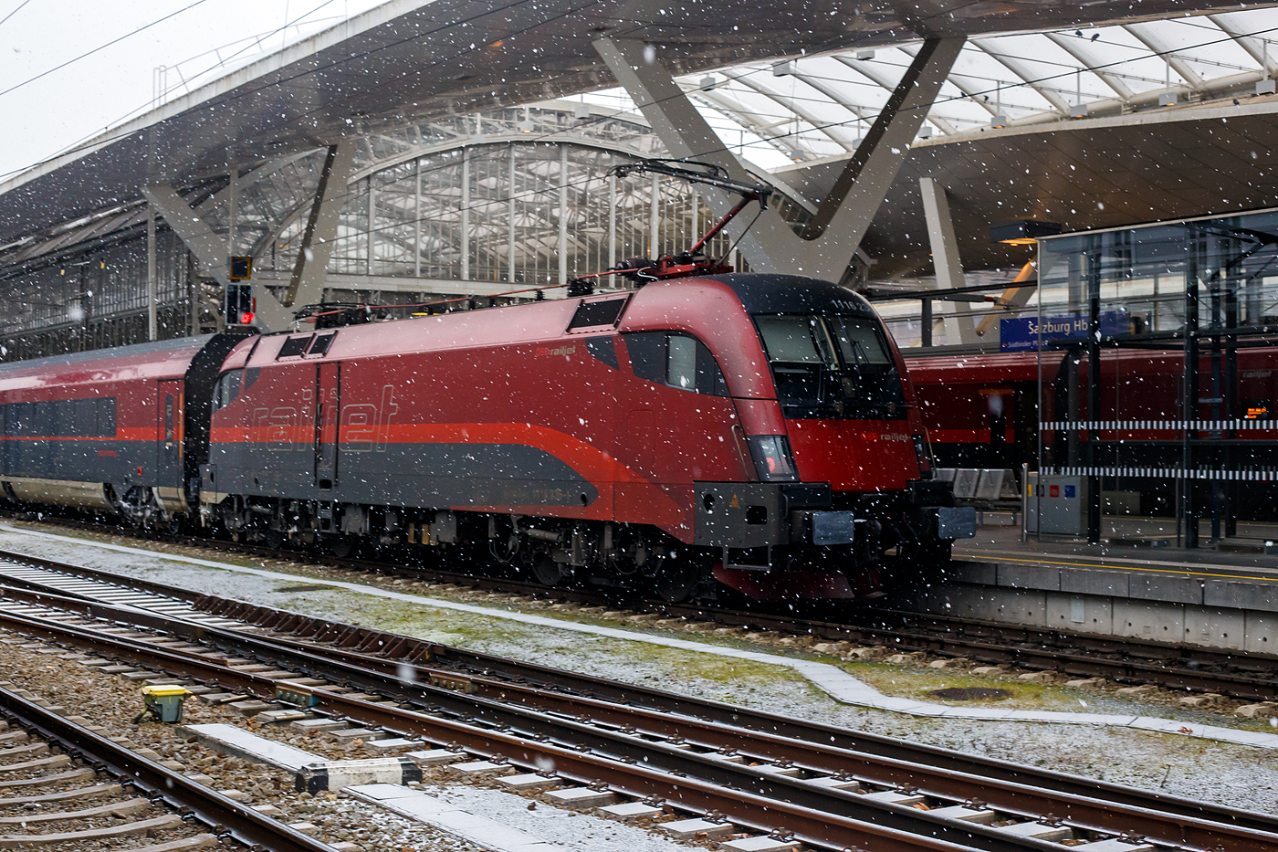 Salzburg Hauptbahnhof am 15 Januar 2025, nun schneit es leicht, die letzten Passagiere sind aus dem ÖBB-Railjet von Wien Hbf. ausgestiegen und die ÖBB-Railjet 1116 236 (A-ÖBB 91 81 1116 236-1) schiebt/drückt nun den Zug in die Abstellgruppe.