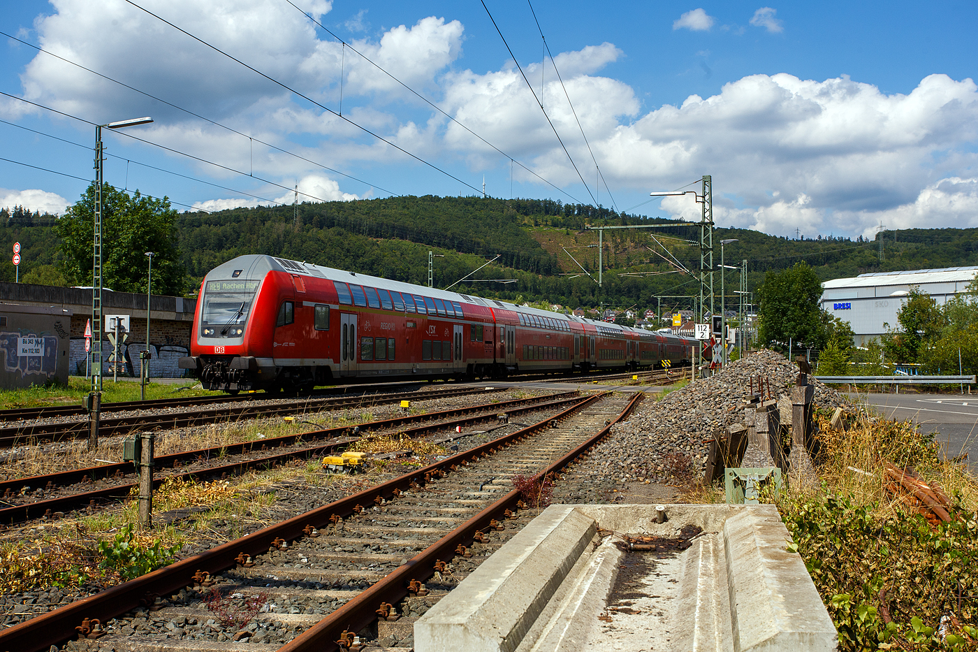 Steuerwagen voraus fährt am 22 Juli 2024 der RE 9 (rsx - Rhein-Sieg-Express) Siegen – Köln –Aachen, der DB Regio NRW durch Niederschelden bzw. Niederschelderhütte in Richtung Betzdorf (Sieg), hier beim Bü 343 – km 112,183 der Siegstrecke KBS 460. Der Zug überquert hier, wie so oft, die Sieg und somit die Landesgrenze von Nordrhein-Westfalen und Rheinland-Pfalz. Die Lok und der hintere Zugteil befinden sich in Siegen-Niederschelden (Nordrhein-Westfalen), der Steuerwagen und der 2. Wagen befinden sich nun in Mudersbach-Niederschelderhütte (Rheinland-Pfalz). 

Schublok war die 146 003-9.