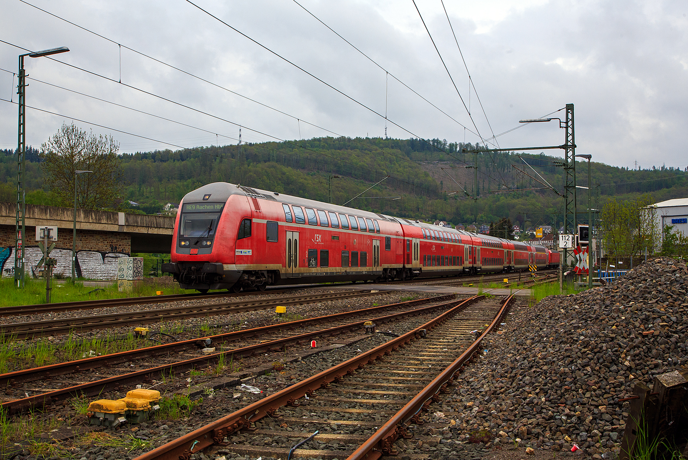 Steuerwagen voraus fährt der RE 9 rsx - Rhein-Sieg-Express (Siegen – Köln – Aachen) am 11.05.2023 durch Niederschelden in Richtung Betzdorf (Sieg). 

Der Steuerwagen ist der klimatisierte Doppelstock-Steuerwagen 2. Klasse (DoSto-Steuerwagen) D-DB 50 80 86-75 050-4, der Gattung/Bauart DBpbzfa 763.8, Schublok war die 146 003-9 der DB Regio NRW.

Der Steuerwagen wurde 2000 von der DWA Deutsche Waggonbau AG im Werk Görlitz (ex Waggonbau Görlitz, heute Bombardier) gebaut und in der Gattung/Bauart DBpbzfa 763.6, an die DB Regio NRW für den RE 9 – rsx, geliefert. Die ab 1999 neu beschafften Steuerwagen sind mit einem vergrößerten behindertengerechtem WC ausgestattet, welches die Bauart DBpbzfa 763.6 charakterisiert. Im Oktober 2016 erfolgte im AW Wittenberge der Umbau, wobei der Wagen mit einem zweiten Mehrzweckbereich nachgerüstet und in damit in die Bauart DBpbzfa 763.8 umgezeichnet wurde.

TECHNISCHE DATEN:
Hersteller: DWA Deutsche Waggonbau AG, Werk Görlitz (heute Bombardier)
Umbau bei: AW Wittenberge (2013 bis 2016)
Spurweite: 1.435 mm
Länge über Puffer: 27.270 mm
Wagenkastenlänge: 26.660 mm
Wagenkastenbreite: 2.784 mm
Höhe über Schienenoberkante: 4.631 mm
Drehzapfenabstand: 20.000 mm
Achsstand im Drehgestell: 2.500 mm
Drehgestell Bauart: Görlitz VIII
Leergewicht: 53 t
Höchstgeschwindigkeit: 160 km/h
Heizungsbauart:  Klimaes
Bremsbauart: KE-PR-A-Mg-mZ (D)
Sitzplätze: 85 in der 2. Klasse
Toiletten: 1, behindertengerecht, geschlossenes System
Bemerkungen: 2 Mehrzweckabteile, 1 Dienstraum, eingeschränkt dieselloktauglich
Umgebaut aus: DBpbzfa 763.6