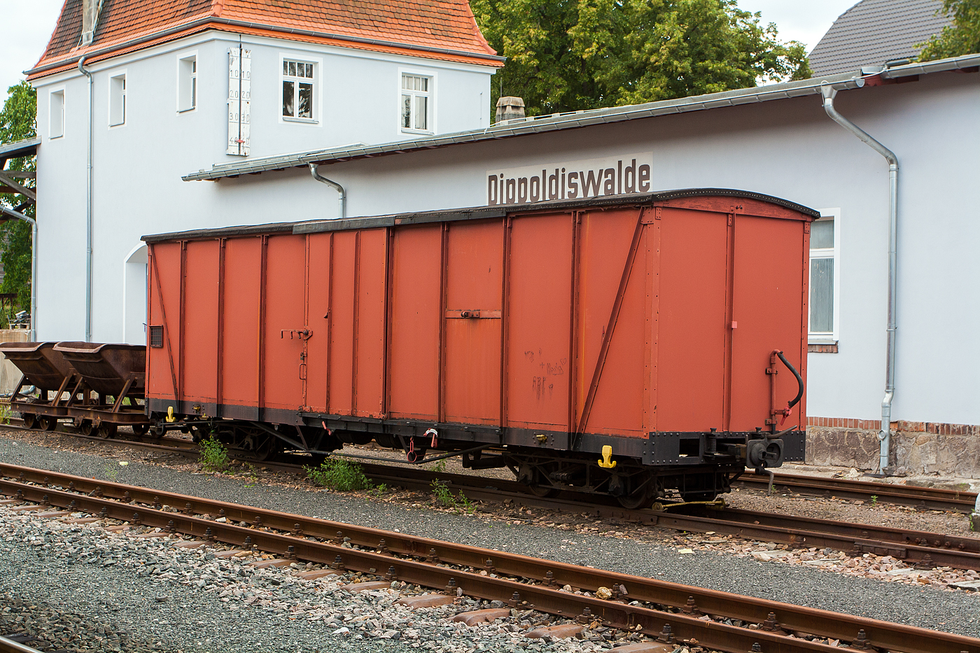 Unbekannter vierachsiger gedeckter Güterwagen der Gattung GGw (750mm-Schmalspur-Drehgestell-Wagen) und dahinter noch zwei Kipploren abgestellt am 26 August 2013 beim Bahnhof Dippoldiswalde der Weißeritztalbahn.