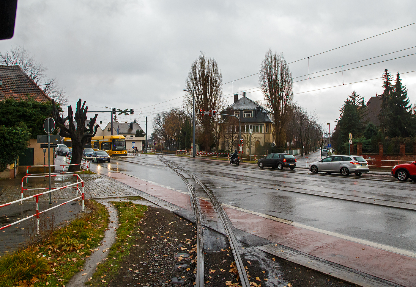 Unterwegs mit der Lößnitzgrundbahn der SDG - Sächsische Dampfeisenbahngesellschaft mbH, unser Zug hat am 07.12.2022 den Haltepunkt Weißes Roß erreicht, wir müssen aber noch ein Stück vorrollen damit die Sicherungstechnik den kurz davor liegenden  Bü 1,5 - Meißner Straße freigegeben kann. Erst dann öffnen die Schranken und der Verkehr kann weiter fahren, auch der NGT 6 DD Zweirichtungs-Niederflur-Gelenktriebwagen DVB 2582 als Dresdner Straßenbahnlinie 4.