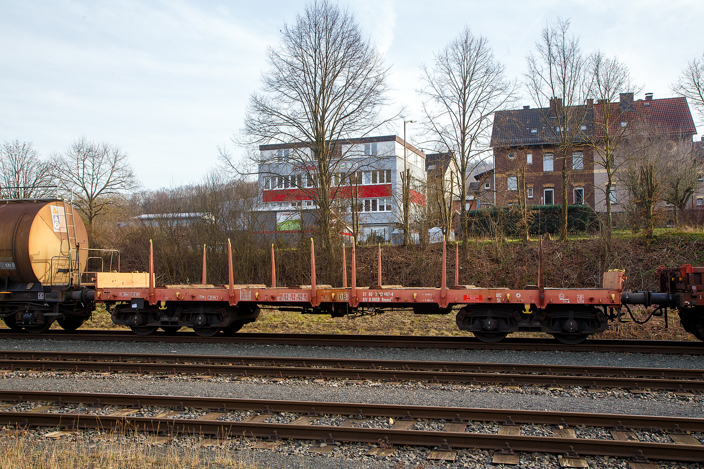 Vierachsiger Drehgestell-Flachwagen mit Drehrungen und Stirnwandklappen, 31 80 3962 497-4 D-DBSR, Gattung Rmms 664, der DB Cargo Romania SRL (ex DB Schenker Rail Romania), am 09.02.2023 leer abgestellt auf dem KSW Rbf Herdorf (Betriebssttte Freien Grunder Eisenbahn - NE 447).

Der Wagen wurde 1976 von der Waggon Union in Berlin gebaut.

Der Wagen ist fr den Transport von Walzwerkerzeugnissen Straenfahrzeugen einschl. Kettenfahrzeugen, Erzeugnissen der Bauindustrie, usw. geeignet. Die an den Stirnseiten angeordneten berfahrklappen gestatten abgeklappt das Durchfahren von Gleisbgen mit mindestens 150 m Halbmesser. Die berfahrklappen liegen im abgeklappten Zustand auf 4 Konsolen auf. In senkrechter Stellung werden sie durch je 2 am Kopfstck angeordneten Fallrungen gehalten. Je Wagenlngsseite sind 6 absenkbare Drehrungen vorhanden. Der Fuboden besteht aus Kiefernbohlen mit den Abmessungen 70 x 180 mm. Er kann eine Radlast von 5,0 t aufnehmen. Im Fuboden sind 6 geteilte, klappbare Ladeschwellen eingebaut. Die Wagen haben eine Klotzbremse mit stufenlos, selbstttiger Lastabbremsung.

TECHNISCHE DATEN:
Spurweite: 1.435 mm (Normalspur)
Gattung/Bauart: Rmms 664
Erstes Baujahr: 1968
Anzahl der Achsen: 4 in 2 Drehgestellen
Lnge ber Puffer: 14.040 mm
Drehzapfenabstand: 9.000 mm
Achsabstand im Drehgestell: 1.800 mm
Ladelnge: 12.600 mm
Hchstgeschwindigkeit: 100 km/h (beladen) / 120 km/h (leer)
Eigengewicht: 21.400 kg
Maximale Ladegewicht: 59,0 t (ab Streckenklasse C)
Laufraddurchmesser (neu): 920 mm
Kleinster bef. Gleisbogenradius: 35 m
Bauart der Bremse: KE-GP-A max. 56 t (LL)
Bremssohle: IB 116 
Internationale Verwendungsfhigkeit: RIV