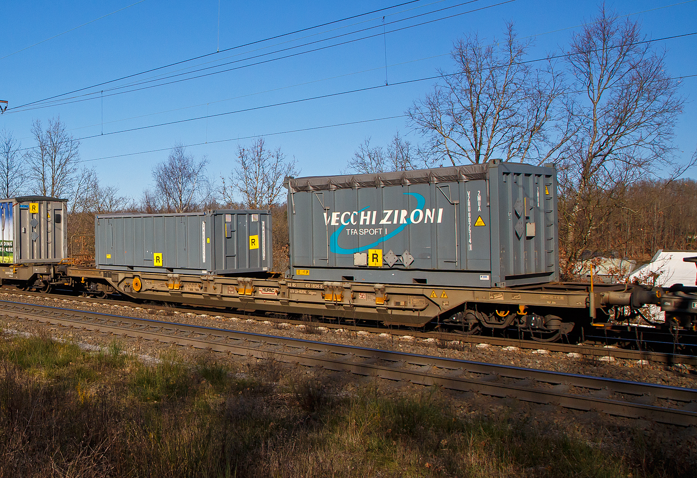 Vierachsiger Drehgestell-Taschenwagen für den Transport von Sattelaufliegern und Container, 33 85 4511 034-2 CH-HUPAC, der Gattung Sdgnss, der HUPAC Intermodal SA, im Zugverband am 07.02.2023, bei der Zugdurchfahrt in Rudersdorf (Kr. Siegen), beladen mit zwei Container.

Diese Wagen wurde in den 1990er Jahren von der Waggonfabrik Talbot in Aachen gebaut.
