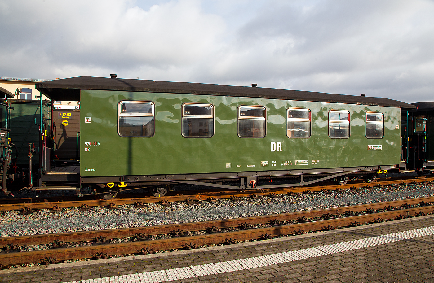 Vierachsiger modernisierter 750 mm-Schmalspur 2.Klasse Personenwagen mit Traglastenabteil, offenen Plattformen und Holzdach, SDG 970-605 (ex DB 970-605, ex DR 970-605), der Gattung KB4 tr, der SDG - Sächsische Dampfeisenbahngesellschaft mbH abgestellt im Zugverband am 07 Dezember 2022 beim Schmalspur-Bahnhof Radebeul Ost (Lößnitzgrundbahn). Hier im 
ehem. Erscheinungsbild der DR. 

Der Wagen wurde 1926 von der von der Sächsische Waggonfabrik GmbH – Werdau gebaut. Er ist einseitig als Traglastenwagen (für Kinderwagen etc.) ausgeführt.

TECHNISCHE DATEN:
Spurweite: 750 mm
Anzahl der Achsen: 4
Länge über Puffer: 12.800 mm
Drehzapfenabstand: 7.500 mm
Eigengewicht: 10 t
Sitzplätze: 29 (in der 2. Klasse)
Bremse: KE-P
