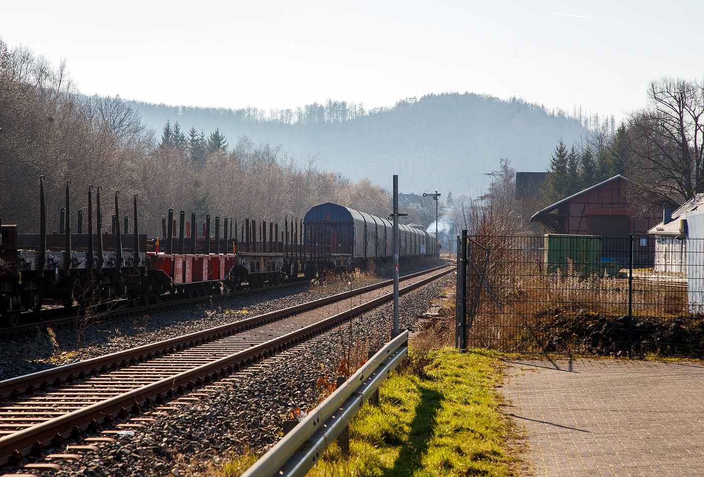 ....von hinten drückt die KSW 46 bzw. 277 807-4 (92 80 1277 807-4 D-KSW), die Vossloh G 1700-2 BB der Kreisbahn Siegen-Wittgenstein, den langen Übergabezug der KSW am 03.03.2023 aus dem Bahnhof Herdorf nun ich Richtung Dillenburg. Es wird im Sandwich gefahren, vorne zieht die KSW 42 (92 80 1277 902-3 D-KSW).