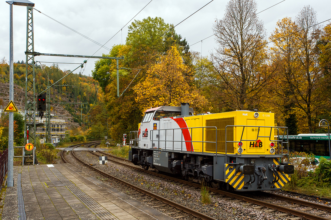 Welch seltener Gast auf der Siegstecke, auch wenn Triebzüge und -wagen der HLB hier Alltag sind, ist die Güterlok der HLB meist in und um Kassel unterwegs. Die Diesellokomotive 275 024-8, alias DG 1131 (92 80 1275 024-8 D-HEB), die Vossloh/MaK G 1206 der HLB - Hessische Landesbahn GmbH, hat am 16 Oktober 2025, auf den Weg in Richtung Köln, im Bahnhof Kirchen/Sieg Hp 0, da es eine Weichenstörung gab. Nun fährt sie weiter in Richtung Betzdorf bzw. Köln.

Die MaK G 1206 wurde 2001 von der VSFT - Vossloh Schienenfahrzeugtechnik GmbH in Kiel-Friedrichsort unter der Fabriknummer 1001131 gebaut und an die LC - Locomotion Capital Ltd. (London) als Mietlok geliefert. 

Lebenslauf/Stationen und Bezeichnungen:
•	Dezember 2001 - Vermietung an NE - Städtische Hafenbetriebe Neuss
•	Januar 2002 - Vermietung an StEK - Städtische Eisenbahn Krefeld 
•	Januar 2002 - Vermietung an Niederrheinische Verkehrsbetriebe AG (NIAG) 
•	Januar/Februar 2002 - Vermietung an OHE- Osthavelländische Eisenbahn AG 
•	Februar 2002 bis August 2003 - Vermietung an IL - InfraLeuna Infrastruktur- und Service GmbH, als IL 206
•	April 2003 - Verkauf an ATC - Angel Trains Cargo SA, Antwerpen (B)
•	August 2003 bis - Vermietung an RBH - RAG Bahn und Hafen GmbH als  RBH 841  
•	April bis Juni 2005 - Vermietung an MEG - Mitteldeutsche Eisenbahn GmbH  MEG 298  
•	November 2005 bis Oktober 2006 - Vermietung an MVG - Mülheimer Verkehrsgesellschaft mbH, Mülheim (Ruhr)  2  
•	November 2006 bis 2013 Vermietung an CFL - Société Nationale des Chemins de Fer Luxembourgeois bzw. CFL Cargo als 1504. Ab 2007 dann NVR-Nummer 92 82 0001 504-0 L-CFLCA. Zum 01.01.2010 aus der ATC wird die Alpha Trains Belgium NV/SA. 
•	Juni 2013 bis Dezember 2014 - Vermietung an HLB - Hessische Landesbahn GmbH  
•	31.12.2014 - Verkauf an die HLB - Hessische Landesbahn GmbH, Betreiber Bezeichnung  DG 1131 , vergabe der NVR-Nummer 92 80 1275 024-8 D-HEB. Auffällig ist das sie, trotz der längeren Einsatzdauer in Luxemburg, heute nur die UIC-Zulassung für Deutschland (D) hat. 

Die MaK G 1206 ist im schweren Rangier- und Streckendienst einsetzbar. Sie wurde 1997 zum ersten Mal gebaut und ist nach Deutschland, Österreich, der Schweiz, Luxemburg, Italien, Spanien, den Niederlanden und nach Frankreich verkauft worden. Allein 23 Lokomotiven fahren als BB 61000 bei der SNCF, davon sechs mit MTU-Motor (Die G 1206 gibt es wahlweise mit Caterpillar- oder MTU-Motor). Diese Lok hat einen Caterpillar 12 Zylinder 4-Takt Dieselmotor mit Abgasturbolader und Ladeluftkühlung vom Typ 3512B DI TA-SC mit einer Leistung von 1.500 kW bei1.800 U/min. Das Strömungsgetriebe ist ein Voith L 5r4 zU2.
