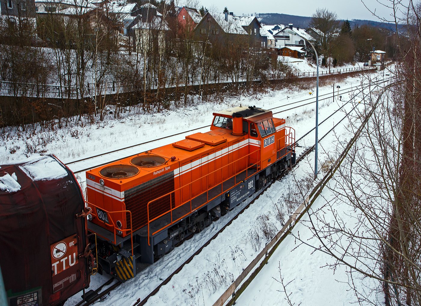 Zurzeit ist die RBH 802 „Ruhrpott Sprinter“ / 275 802-3 (98 80 0275 802-3 D-RBH), eine MaK G 1206 der RBH - RAG Bahn und Hafen GmbH (Gladbeck), an die KSW (Kreisbahn Siegen-Wittgenstein) vermietet. Hier steht sie mit einem Übergabegüterzug, auf dem Rbf der KSW in Herdorf (Betriebsstätte Freien Grunder Eisenbahn- NE 447) vor der Gleisspeere zur Hellertalbahn, zur Abfahrt bereit. Der Zug geht dann via Betzdorf/Sieg und Siegen zum Gbf der DB Cargo in Kreuztal.

Die MaK G 1206 wurde 1997 von der Siemens Schienenfahrzeugtechnik (SFT) in Kiel-Friedrichsort unter der Fabriknummer 1000901 gebaut und an die damalige RAG - Ruhrkohle AG, RAG Bahn- und Hafenbetriebe in Gladbeck als RAG 802 ausgeliefert. Sie war erst die zweite gebaute Lok der erfolgreichen Typs G 1206 aus dem 3. Typenprogramm. Im Jahr 2004 erfolgte die Umfirmierung der RAG in RAG Bahn und Hafen GmbH (RBH) und nach der Übernahme durch die DB Schenker Rail Deutschland AG (heute DB Cargo) erfolgte 2006 die Umfirmierung in RBH Logistics GmbH. 

Die SFT war die Nachfolgefirma der Krupp Verkehrstechnik GmbH bzw. der früheren Maschinenbau Kiel GmbH (MaK). Die SFT wurde am 1. Oktober 1998 von Siemens an die Vossloh AG verkauft, in Vossloh Schienenfahrzeugtechnik (VSFT) umbenannt und firmierte seit 23. April 2004 als Vossloh Locomotives GmbH. Die Vossloh-Lokomotiven aus Kiel trugen das Kürzel MaK in der Fahrzeug-Typenbezeichnung. Nach der Fokussierung von Vossloh auf den Bereich Schiene erfolgte 2019 ein weiterer Verkauf an die Chinesische CRRC Zhuzhou Locomotive Co., Ltd.

Die Lok (MaK G 1206):
Die MaK G 1206 ist im schweren Rangier- und Streckendienst einsetzbar. Sie wurde 1997 zum ersten Mal gebaut, erster Kunde war die RAG, somit diese (die 804) erst die Vierte der Serie. Bis 2016 wurden insgesamt 323 Fahrzeuge der Baureihe G 1206, in 5 verschiedenen Varianten, produziert. Sie wurden nach Deutschland, Österreich, der Schweiz, Luxemburg, Italien, Spanien, den Niederlanden und nach Frankreich verkauft worden. Allein 23 Lokomotiven fahren als BB 61000 bei der SNCF, davon sechs mit MTU-Motor (Die G 1206 gibt es wahlweise mit Caterpillar- oder MTU-Motor). 

Diese Lok der ersten Serie (von 11 Stück) hat einen wassergekühlten 90°V16- Zylinder-Viertakt-Dieselmotor mit Abgasturbolader und Ladeluftkühlung, sowie mit Direkteinspritzung, vom Typ MTU 16V 396 TC 14 des Herstellers MTU Friedrichshafen GmbH (MTU steht für Motoren- und Turbinen-Union). Der Motor hat ein Zylinderbohrung von 165 mm und einen Kolbenhub von185 mm, damit hat der Motor einen Hubraum von 63.3 Litern. Die Motorleistung beträgt 1.570 kW (2.135 PS) bei 1.800 U/min, solche Leitungen erbringe heute 12 Zylindermotoren. Das Strömungsgetriebe ist ein Voith L 5r4 zU2. Die Höchstgeschwindigkeit der Lok beträgt 80 km/h.

Die G 1206 nimmt im 3. Typenprogramm eine besondere Rolle ein. Sie ist nicht nur die größte und leistungsstärkste Mittelführerhaus-Lok als Schlusspunkt dieser Typenreihe, sondern hat mit ihrer Verbreitung in vielen Ländern Europas inzwischen eine gebaute Stückzahl erreicht wie noch keine unabhängig von Staatsbahnaufträgen entwickelte Standardlok aus Kiel vor ihr. Was 1997 als neue Lokgeneration für die Ruhrkohle AG begann, ist heute eine Lokomotive, die in acht europäischen Ländern bei zahlreichen Bahnen, darunter zwei Staatsbahnen, im Einsatz steht.

Mitte der 1990er Jahre entstand bei den Bahn- und Hafenbetrieben der Ruhrkohle AG Bedarf nach neuen Diesellokomotiven. Diese Maschinen sollten nicht nur im schweren internen Rangier- und Zustelldienst eingesetzt werden, sondern auch - die Möglichkeiten der Liberalisierung nutzend - mit schweren Kohlezügen auf Strecken der DB AG verkehren. Dafür benötigten die Lokomotiven eine entsprechend hohe Motorleistung und eine Höchstgeschwindigkeit, die einen freizügigen Einsatz auf DB-Gleisen zulässt.

Den Auftrag zur Entwicklung und Lieferung von elf dieser Lokomotiven bekam die damalige Siemens Schienenfahrzeugtechnik GmbH. Das Ergebnis war die G 1206, deren erstes Exemplar Ende Juli 1997 an die RAG ausgeliefert wurde. Sie ist aus der G 1205 entwickelt worden und unterscheidet sich von dieser hauptsächlich durch den Dieselmotor mit 16 statt 12 Zylindern und eine entsprechend dimensionierte Kühlanlage mit zwei Lüfterrädern. Um die größere Maschinenanlage auf der Lokomotive unterbringen zu können, ist die G 1206 fast zwei Meter länger als ihre Vorgängerin ausgeführt worden.

Die 5 verschiedenen Varianten unterscheiden sich vor allem an den verwendeten Motoren und Getrieben, wie folgt:
•	Motor MTU 16V 396 TC14 mit 1570 kW; Getriebe L 5r4 zU2; Hg 80 km/h
•	Motor MTU 16V 396 TC14 mit 1570 kW; Getriebe L 5r4 zseU2; Hg 60 / 100 km/h
•	Motor MTU 12V 4000 R20 mit 1500 kW; Getriebe L 5r4 zU2; Hg 80 km/h
•	Motor Caterpillar 3512B DI TA mit 1500 kW; Getriebe L 5r4 zU2; Hg 100 km/h
•	Motor MTU 12V 4000 R41 mit 1500 kW; Getriebe L 5r4 zseU2; Hg 60 / 100 km/h

TECHNISCHE DATEN der G 1206 der 1. Serie (RAG):
Spurweite: 1.435 mm (Normalspur)
Antriebart:  dieselhydraulisch
Achsfolge: B'B' 
Länge über Puffer: 14.700 mm
Drehzapfenabstand: 7.200 mm
Achsabstand im Drehgestell: 2.400 mm
größte Breite: 3.080 mm
Höhe über Schienenoberkante: 4.220 mm
Raddurchmesser: 1.000 mm (neu)
Motor: MTU 16V 396 TC14 
Leistung: 1.570 kW bei1.800 U/min
Strömungsgetriebe: Voith L 5r4 zU2
Anfahrzugkraft: 291 kN
Höchstgeschwindigkeit: 80 km/h
kleinster befahrbarer Gleisbogen: 60 m
Dienstgewicht: 88 t
Kraftstoffvorrat: 3.150 l
