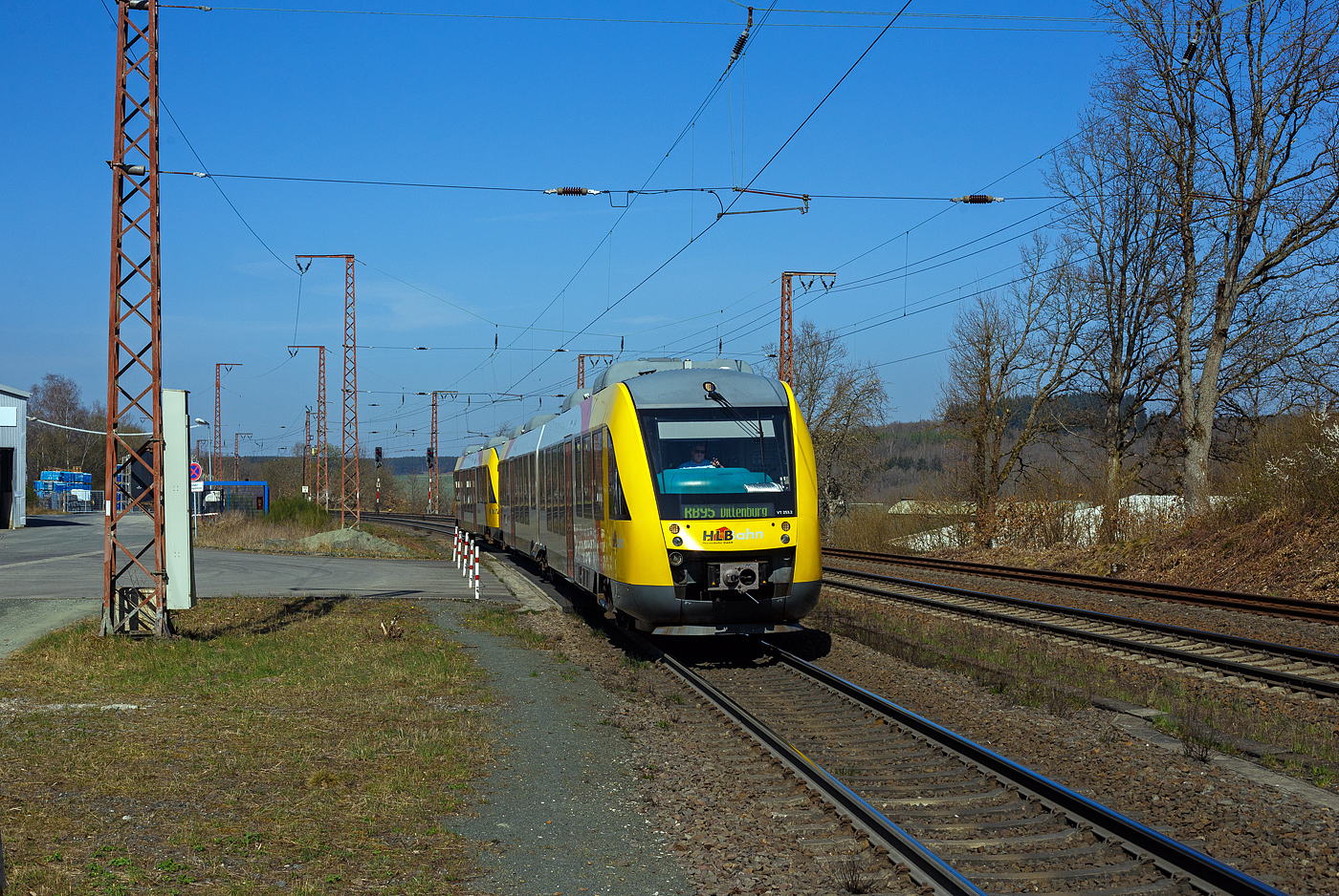 Zwei gekuppelte Dieseltriebz�ge vom Typ Alstom Coradia LINT 41 und 27, der HLB (Hessische Landesbahn GmbH), erreichen am 12 April 2025, als RB 95  Sieg-Dill-Bahn  (Siegen - Dillenburg) den Hp Wilnsdorf-Rudersdorf (Kr. Siegen). Vorne der LINT 41 - VT 253 (95 80 0648 153-4 D-HEB / 95 80 0648 653-3 D-HEB) und dahinter der LINT 27 - VT 201 ABp (95 80 0640 101-1 D-HEB). 

Nochmals einen lieben Gru� an den netten Lokf�hrer zur�ck.

Beide Alstom Coradia LINT wurden 2004 von Alstom, vormals Linke-Hofmann-Busch GmbH (LHB) ) in Salzgitter-Watenstedt gebaut, der LINT 41 unter der Fabriknummer 1188-003 und der LINT 27 unter der Fabriknummer 1187-001. Beide wurden an die vectus Verkehrsgesellschaft mbH geliefert, mit dem Fahrplanwechsel am 14.12.2014 wurden alle Fahrzeuge der vectus nun Eigentum der HLB, die Hessische Landesbahn hatte 74,9% der Gesellschaftsanteile.