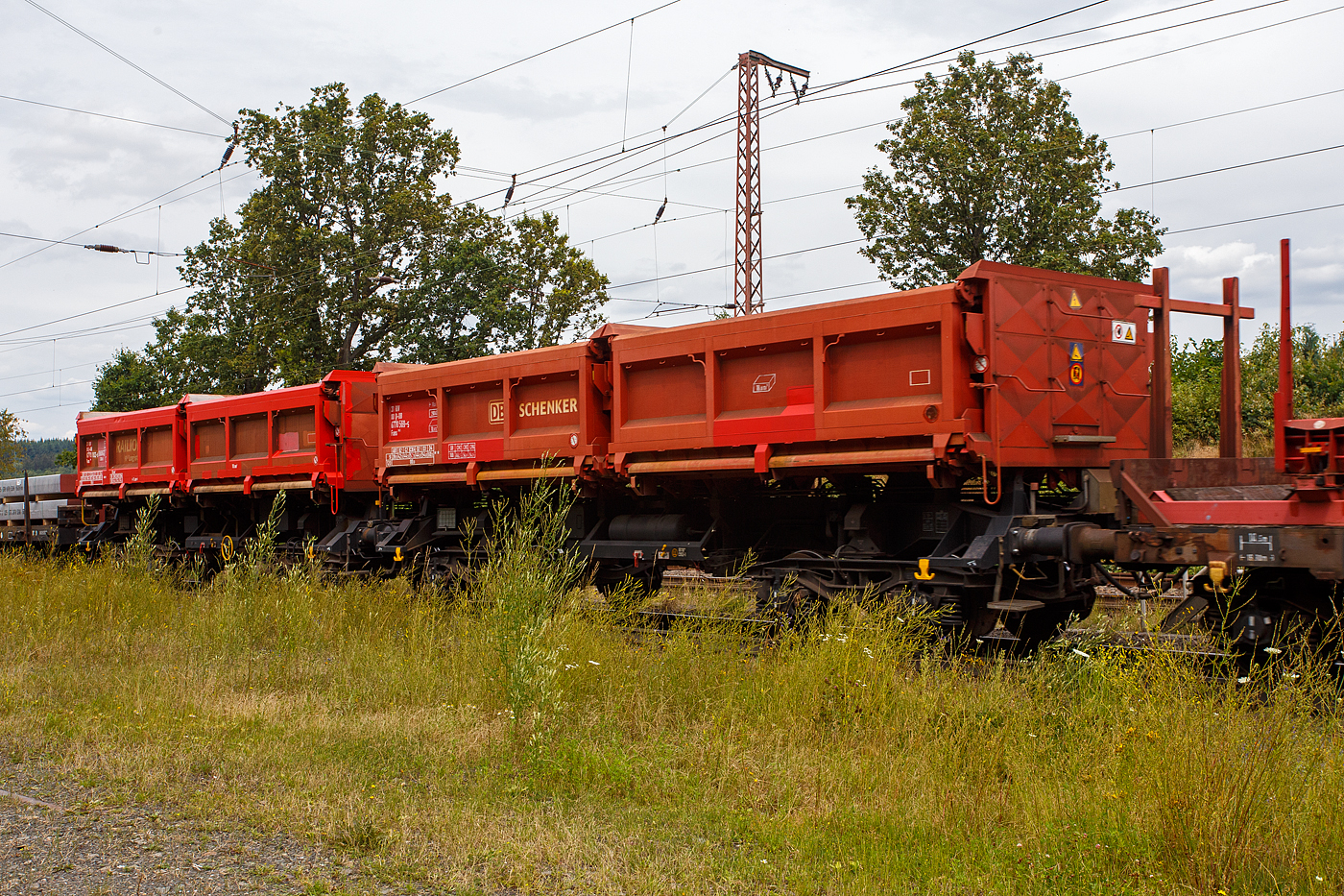 Zwei vierachsige zweimuldige Drehgestell-Schüttgutkippwagen mit elektrohydraulischer Betätigung, der Gattung Fans 128, der DB Cargo Deutschland AG, am 19 Juli 2024 im Zugverband bei einer Zugdurchfahrt durch Rudersdorf (Kreis Siegen). Vorne der Wagen 31 80 6770 569-5 D-DB (ohne Feststellbremse) und dahinter der 31 80 6770 102-5 D-DB (mit Feststellbremse).

Der zweimuldige Drehgestell-Schüttgutkippwagen (Zweiseiten-Kastenkipper) ist für den Transport von feuchtigkeitsunempfindlichen Schüttgütern wie z.B. Splitt, Kies, Schotter, erdfeuchtem Sand, Bodenaushub oder Bauschutt vorgesehen. Der Wagen besitzt einen elektrohydraulischen Kippantrieb und eine speicherprogrammierbare Steuerung (SPS). Entwickelt und in Serie gebaut wurde der Kastenkipper vom FEW Fahrzeug- und Entwicklungswerk Blankenburg (Harz) der DB AG. Die Drehgestelle liefert das Werk Halle, die Wagenkästen fertigen das Werk Kaiserlautern und DWA Niesky.

Für den Einsatz als Einzelwagen, in Wagengruppen oder beim Massenschüttgut-Transport in Ganzzügen besitzt er eine autarke Wagentechnik, die eine von äußeren Energiequellen unabhängige Entladung ermöglicht. Das Schüttgut kann als Nah- oder Weitablage abgegeben werden. Das Schüttgut beiden Seiten gekippt werden. Der Wagen verfügt über zwei getrennt kippbare Mulden. Die Wagen haben eine Batterie die über Achsgeneratoren (hier im Bild an der 2. Achse von rechts) aufgeladen werden.

TENISCHE DATEN:
Erstes Lieferjahr: 1996
Spurweite: 1.435 mm (Normalspur)
Länge über Puffer: 11.600 mm
Drehzapfenabstand: 6.580 mm
Achsabstand im Drehgestell: 1.800 mm
Drehgestell-Bauart: Y 25 Lsd 1 - 629
Laufraddurchmesser: 920 mm (neu)
Laderaum: 2 x 18,0 m³
Ladefläche: 2 × 12,0 m²
Höhe der Beladeöffnung: 3.512 mm
Kippwinkel des Kastens: 45°
Kippantrieb Energieversorgung: autark, über Batterie geladen über Achsgenerator
Kippantrieb Kapazitätsverbrauch pro Entladung: 5 bis 10 (Ah)
Kippbewegungen: über zwei Hydraulikzylinder je Kasten
Höchstgeschwindigkeit: 120 km/h (leer) / 100 km/h (beladen)
Eigengewicht: 29.400 bzw. 29.300 kg
Maximales Ladegewicht: 60,5 t (ab Streckenklasse D4), oder DB CM4 54,5 t
Kleinster bef. Gleisbogenradius: 75 m
Bremse: KE-GP-A (LL)
Bremssohle: IP 116
Intern. Verwendungsfähigkeit: RIV

Der Wagen ist zum Transport von witterungsunempfindlichem Schüttgut (mit einer max. Kantenlänge von 40 cm). Der Aufbau besteht aus zwei einzeln kippbaren Kästen mit einem Fassungsvermögen von je 18 m³, die wahlweise nach rechts oder links gekippt werden können. Dabei besteht die Möglichkeit, die Abwurfweite in zwei Stufen zu variieren; „nah“ für die Tiefbunkerentleerung und „weit“ für das ebenerdige Abkippen. Für die Bedienung des Wagens befinden sich an den Stirnwänden zwei diagonal angeordnete Bedientableaus. Der gesamte Kippvorgang erfolgt nach Vorwahl der gewünschten Funktion vollautomatisch. Die entsprechenden Magnetventile werden dabei elektrisch angesteuert. Bei Ausfall des elektrohydraulischen Kippantriebes (z.B. entladene Batterie) können mittels Handpumpe und Betätigung der Handnotbetätigung an der entsprechenden Wegeventilgruppe die Hydraulikzylinder bewegt werden. Eine detaillierte Anweisung für das Vorgehen bei Ausfall ist in jedem Wagen im Batteriekasten deponiert.
