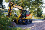 Liebherr Zweiwegebagger A 922 Rail Litronic mit Abstützpratzen, interne Nr. 61922 der Wilhelm Hundhausen GmbH & Co. KG, Siegen, eigestellt unter der Kleinwagen Nr. D-HHBAU 99 80 9903 752-0 abgestellt am 07 September 2024 in der Abstellgruppe in Kreuztal. 

Der A 922 Rail Litronic kann als Zweiwegemaschine wahlweise auf der Straße oder auf Eisenbahnschienen eingesetzt werden. An beiden Seiten des Unterwagens ist das Schienenfahrwerk angebracht. Während des Aufgleisens bringt das Schienenfahrwerk die Bereifung auf Schienenniveau, wobei die inneren Räder der Zwillingsbereifung den Fahrantrieb auf der Schiene übernehmen.

TECHNISCHE DATEN:
Spurweite: 1.435 mm (Normalspur)
Länge über Puffer: 6.400 mm
Achsabstand (Schiene): 5.700 mm
Laufraddurchmesser (Schiene): 500 mm (neu)
Eigengewicht: 23 t
Motorbauart: wassergekühlter 4Takt - 4-Zylinder-Reihendieselmotor mit Common-Rail-Einspritzsystem, Turbolader und Ladeluftkühlung
Motortyp: Liebherr D924 – FPT
Motorhubraum: 4,5 Liter
Motorleistung: 120 kW / 163 PS
Höchstgeschwindigkeit (Hg): 20 km/h (in Kreuzungen und Weichen 10 km/h)
Zugkraft: 117 kN
Bremse: Kfz.-/SFE-Bremse und Wagonbremsanlage
Zul. Anhängelast: 120 t (ungebremst 40 t)
Zur Mitfahrt zugel. Personenzahl: 1 (und Fahrer)
Antrieb auf Schiene: Über Reibantrieb der Straßenreifen
Hinterer Schwenkradius: 2.000 mm
