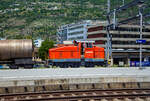 Aus dem Zug heraus, die Em 3/3 163  Rene  (98 85 5837 910-9 CH-LONZA) eine Henschel DHG 500 C der Lonza Group AG (Visp), am 26.05.2023 mit einem Kesselwagenzug im Bahnhof Visp.