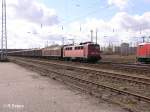 140 752-7 durchfhrt Eisenhttenstadt mit ein langen gedeckten Gterzug.