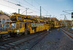 Die Plasser & Theurer Planumssanierungs- und Reinigungsmaschine RPM-RS-900 „Katharina die Große“ der SPITZKE SE (Großbeeren), Schweres Nebenfahrzeug Nr. D-SPAG 99 80 9415 004 – 1 (ex 97 19 35 501 18-1), am 09.11.2021 bei einer Zugdurchfahrt in Betzdorf (Sieg) in Richtung Siegen. Vermutlich hat der sehr lange Zug einen Abstecher nach Betzdorf gemacht, damit die Arbeitsrichtung der Maschinen richtig herum stand. 

Da die Maschine nicht auf ganze Bild passt, folgen diesem Bild noch einige Detailbilder.

Neben der über 198 m langen Maschinen bestand der Zug noch aus einigen MFS-Wagen sowie einigen Güterwagen. Der Zug wurde von der SPITZKE eigenen Siemens Smartron 192 007-3 / E 192-SP-100 gezogen.

Die Maschine wurde 2007 von Plasser & Theurer gebaut und besteht im Einzelnen aus:
• Antriebswagen ATW, 99 80 9415 004 – 1 D-SPAG (ex 97 19 35 501 18-1), Fabriknummer 4795
• Siebwagen, Fabriknummer 4796
• Schotteraufbereitungswagen, Fabriknummer 4797
• Aushubmaschine , Fabriknummer 4798
• Stopf-u.  Einschotterungsmaschine SEM, Fabriknummer 4799
• Materialförder- und Siloeinheit MFS 40 D mit Doppelförderband, 99 80 9552 098-2 D-SPAG (ex 97 19 21 558 57-5). Fabriknummer 2140, Baujahr 1992 und 2007 umgebaut
• Übergabewagen mit Kehrbürste für Schotter (RPM-RS 900 UEW), 99 80 9515 002-0 D-SPAG (ex 97 19 35 901 58-9), Fabriknummer 4800


Der große Unterschied zwischen Planumsverbesserungsmaschine und Bettungsreinigungsmaschinen besteht darin, dass Planumsverbesserungsmaschine nicht nur den Schotter ausheben und recyceln kann sondern auch einen Teil des Planums (Unterbau) ausheben. So hat sie auch zwei Aushubketten, eine für den Schotter und eine für das Planum. Zudem kann die RPM vor der Neuschotterung (Recycling- mit Neumaterial) auch wieder eine neue Planumsschutzschicht (PSS-Material) einbringen.

Die RPM-RS-900 wurde für die Planumssanierung und Schotterbearbeitung von Gleisen konzipiert und ist die längste Maschine des SPITZKE-Technikparks. Ihre Stärke liegt in ihrer Vielseitigkeit. Innerhalb eines Maschinenkomplexes werden Planumsverbesserung, Bettungsreinigung und Schotterrecycling realisiert. Der Schotter wird ausgebaut, recycelt, wieder eingebaut, verdichtet und stabilisiert. Der Boden wird ausgehoben, das neue PSS-Material eingebaut, planiert und verdichtet. Alle Arbeitsgänge verlaufen gleisgebunden, ohne Sperrung des Nachbargleises. Das ermöglicht kurze Sperrzeiten und eine hohe Verfügbarkeit des Fahrweges.

TECHNISCHE DATEN:
Spurweite: 1.435 mm
Gesamtlänge über Puffer: 198.240 mm (ohne zus. MFS Wagen)  
max. Breite / max. Höhe : 3.000 mm / 4.650 mm
Fahrzeugprofil: G 2
Gesamtgewicht (leer): ca. 800 t
Gesamtleistung:  ca. 2.800 kW
max. Geschwindigkeit geschleppt: 100 km/h
max. Geschwindigkeit Eigenantrieb: 19 km/h (bei 800 t, bis zu 15 ‰)


Quelle: SPITZKE, eisenbahndienstfahrzeuge.de

Wer noch etwas mehr über die Maschine wissen will, hier der Link zu SPITZKE: http://www.spitzke.com/maschinen/fahrweg/planumsverbesserung-bettungsreinigung-recycling/rpmrs900/