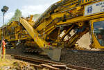 Im Einsatz auf der Hellertalbahn (KBS 462) bei Würgendorf am 15.07.2013: Die Plasser & Theurer Hochleistungs-Bettungsreinigungsmaschine RM 95-800 W, Schweres Nebenfahrzeug Nr. 99 80 9414 001-4 D-MWGB, der MGW Gleis- und Weichenbau-Gesellschaft mbH & Co. KG (Berlin). 

Detailbild im Bereich der Aushubkette, hinter ihr hängt erstmal das Gleis in der Luft, bevor wieder der aufgearbeitete Schotter darunter kommt. Zwar ist es auch möglich Neuschotter dazu zumischen, dies wurde aber hier nicht gemacht. Auch ist es möglich den Altschotter zu waschen, auch dies wurde hier nicht gemacht. Die Maschine war hier auch ohne Wasserkläranlage und Wasserwagen im Einsatz.