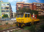 Ein Italienisches Gleisarbeitsfahrzeug mit hydraulischen Benelli Kran B.4000/2 (Autocarrello con gru vom Typ MERMEC MM 87) der RFI - Rete Ferroviaria Italiana (FS Eisenbahninfrastruktur) steht am 19 Juli 2022 bei Augusta (Sizilien). Da die Aufnahme aus einem Zug ist, leider mit Spieglungen. 