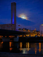 Salzburg by Night und Vollmond: Blick von Station Salzburg Mlln-Altstadt in Richtung Hauptbahnhof, links die Eisenbahnbrcke ber die Salzach (der Bahnstrecke Salzburg - Rosenheim - BB 300) , hier am 13 Januar 2025.