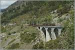 Zwei BLS Re 4/4 mit einem langen Flachwagenzug auf dem Luogelkinn-Viadukt.