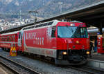 Die RhB Ge 4/4 III – 651  Fideris  mit Werbung fr den Glacier Express ( Glacier on Tour“) steht am 18.02.2017 im Bahnhof Chur mit dem RegioExpress nach St.