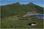 Der neue Jungfraubahn Zug Beh 4/8 auf Bergfahrt und ganz links im Bild, kaum zu erkenne fährt eine blaue WAB Güterlok Talwärts.