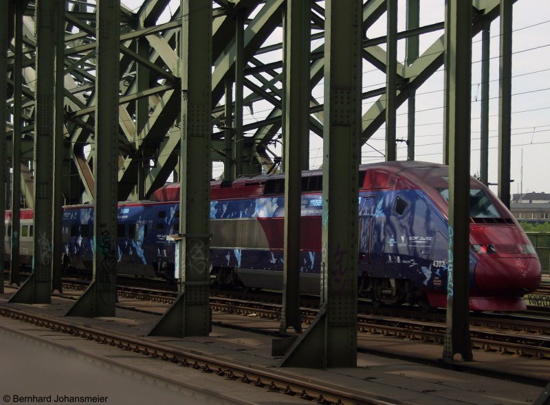 Vielleicht ist dieses Bild vom Werbe-Thalys auf eurer Seite gut aufgehoben. Es ist eingentlich nur ein Notschuss mit einer kleinen Geschichte.
So passiert es fast jedes mal, wenn man ber die Hohenzollernbrcke luft, dass ein besonderer Zug vorbei kommt, den man  nicht richtig  fotografieren kann, weil die Brcke selbst im Weg ist. An diesem Tag war es der Thalys und 111 111-1. Aber es ist mir auch schon passiert, dass ich die Kamera gerade eingepackt hatte und mich die Mrklin 120 159 berholt oder ein Thalys die Sicht auf den berfhrungszug mit Niederlndischen Wagen und einer Kasten 110er versperrte.